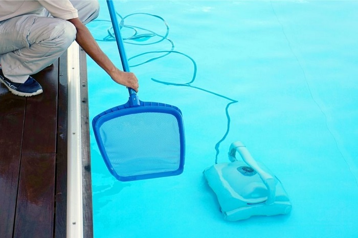 Woman Skimming the pool water