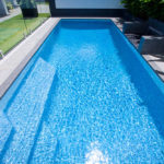 Rectangular fiberglass pool with crystal clear water on it