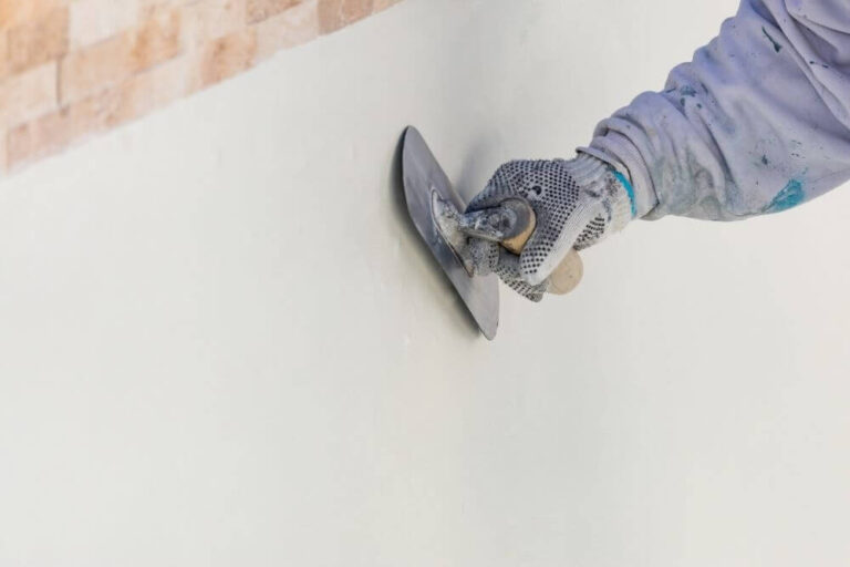 Worker fixing plaster using a trowel