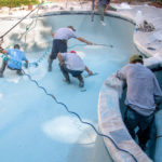 concrete contractors repairing and resurfacing a pool