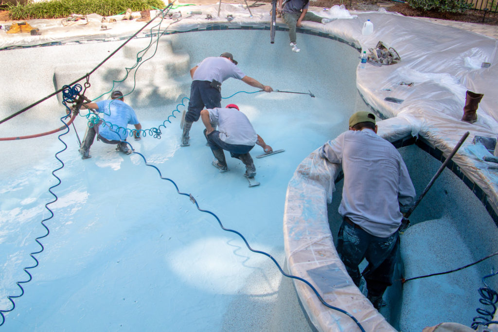 concrete contractors repairing and resurfacing a pool