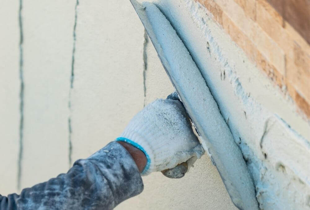 Worker spreading plaster in a pool under construction