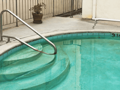 Pool resurfacing to restore smooth and attractive pool surfaces Residential swimming pool with visible surface wear and concrete steps before resurfacing