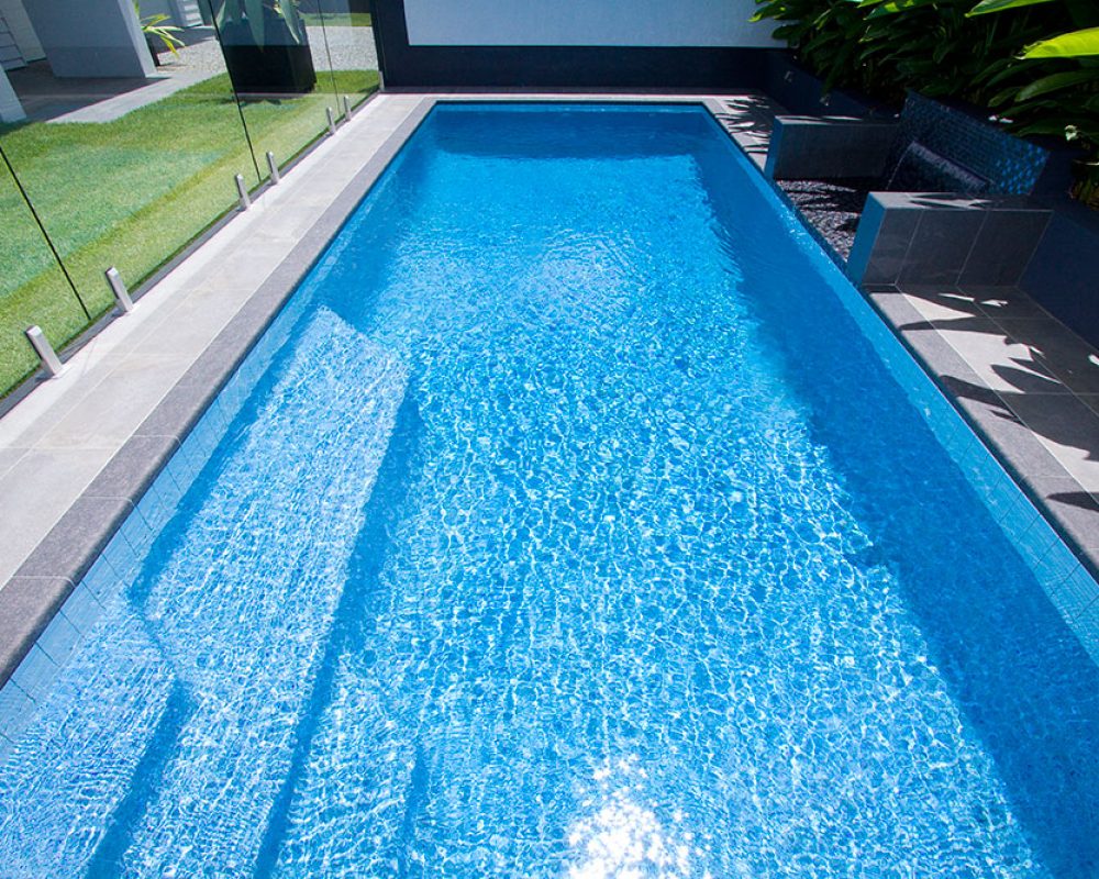 Rectangular fiberglass pool with crystal clear water on it