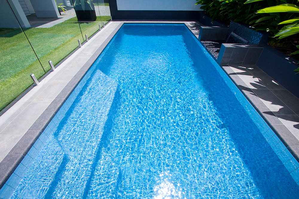 Rectangular fiberglass pool with crystal clear water on it