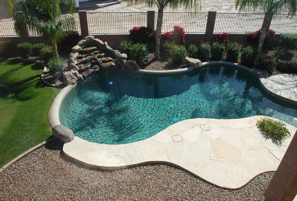 Kidney shaped pool with clear water and features on the side