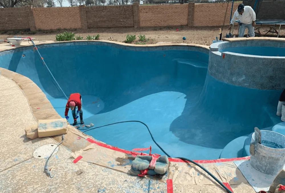 Contractor plastering the swimming pool surface to create a smooth and watertight finish.