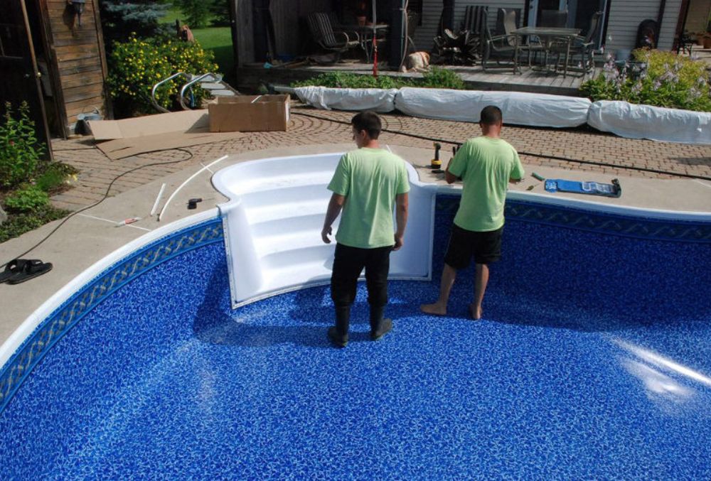 Professional contractor applying pool resurfacing material to restore and smooth the pool surface.