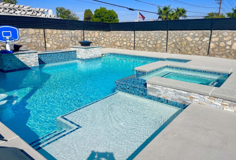 Sparkling swimming pool with a newly resurfaced finish, clear blue water, and a clean, refreshed pool deck.