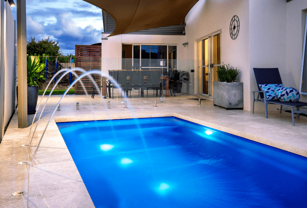 elegant swimming pool with chairs & plants and 2 fountains